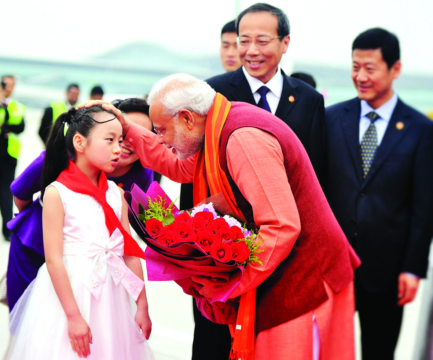 In this handout photograph taken and released by The Indian Press Information Bureau (PIB) on May 14, 2015, India's Prime Minister Narendra Modi (C) receives a floral bouquet from a young Chinese child on his arrival at Xi’an Xiangyang International Airport in Xi’an.  India's Prime Minister Narendra Modi is taking his global investment push to China this week, as Asia's rival superpowers look to put aside a festering border dispute and identify areas of economic cooperation. Modi has arrived for his first visit as premier to China before heading to South Korea where he will also seek help to upgrade India's creaking infrastructure.    AFP PHOTO/PIB  ----EDITORS NOTE---- RESTRICTED TO EDITORIAL USE - MANDATORY CREDIT  - "AFP PHOTO /PIB " - NO MARKETING NO ADVERTISING CAMPAIGNS - DISTRIBUTED AS A SERVICE TO CLIENTS